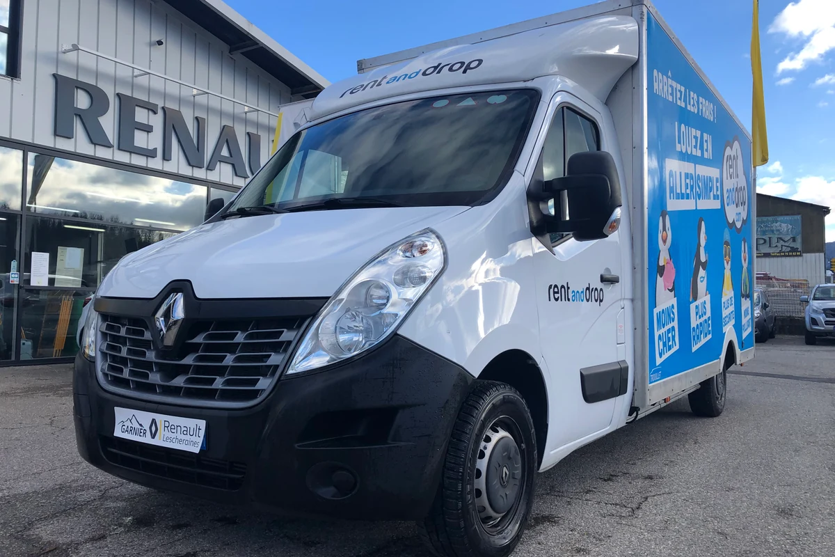 Un camion de déménagement blanc devant l'agence