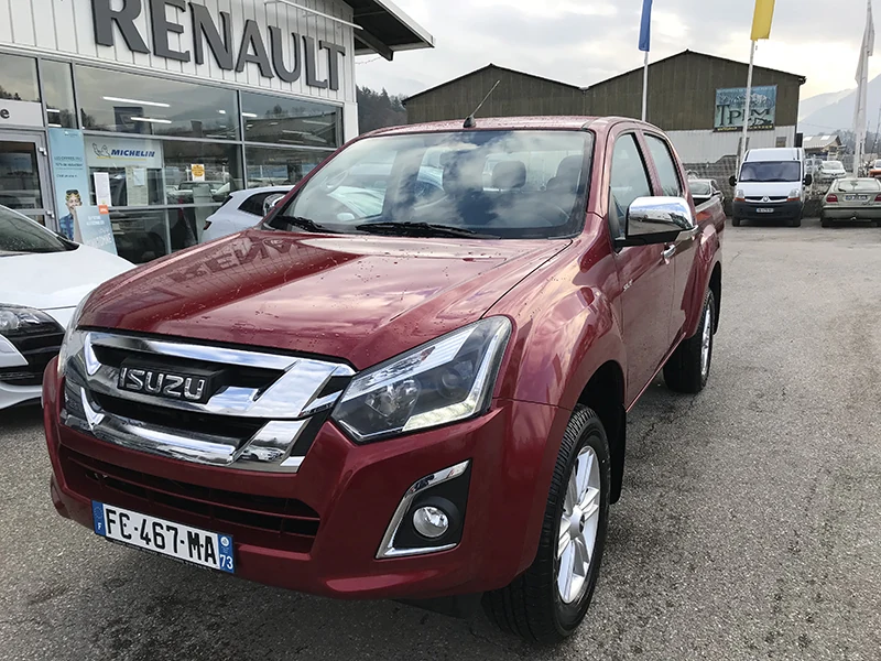 Un pick-up quatre roues motrices rouge devant l'agence de Lescheraines