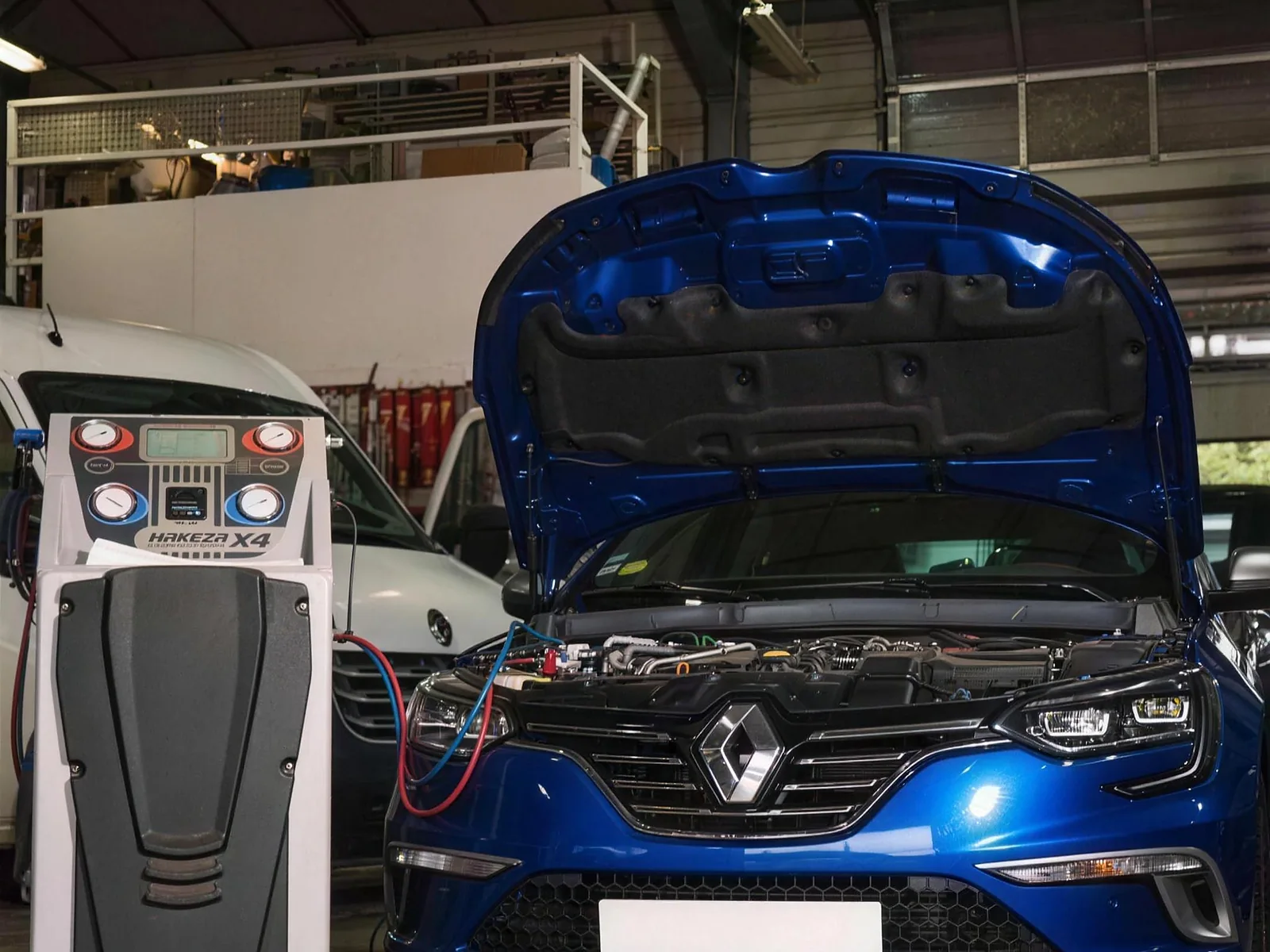 La station de climatisation branchée sur une Renault Mégane, capot ouvert