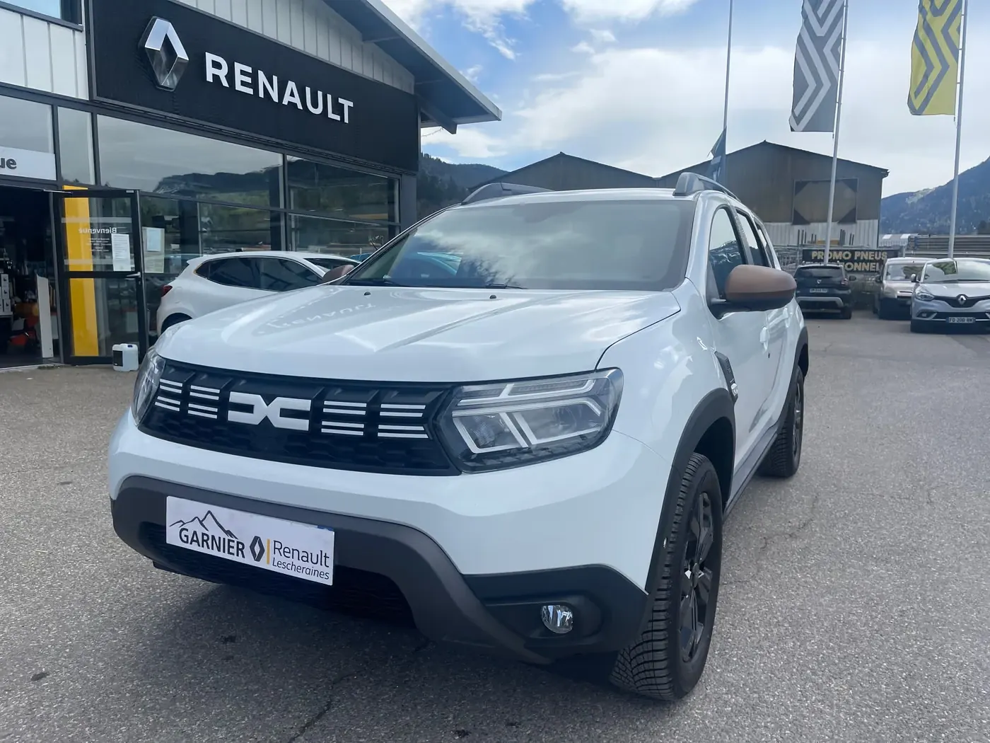 SUV blanc glacier, de trois quarts avant devant l'agence de Lescheraines
