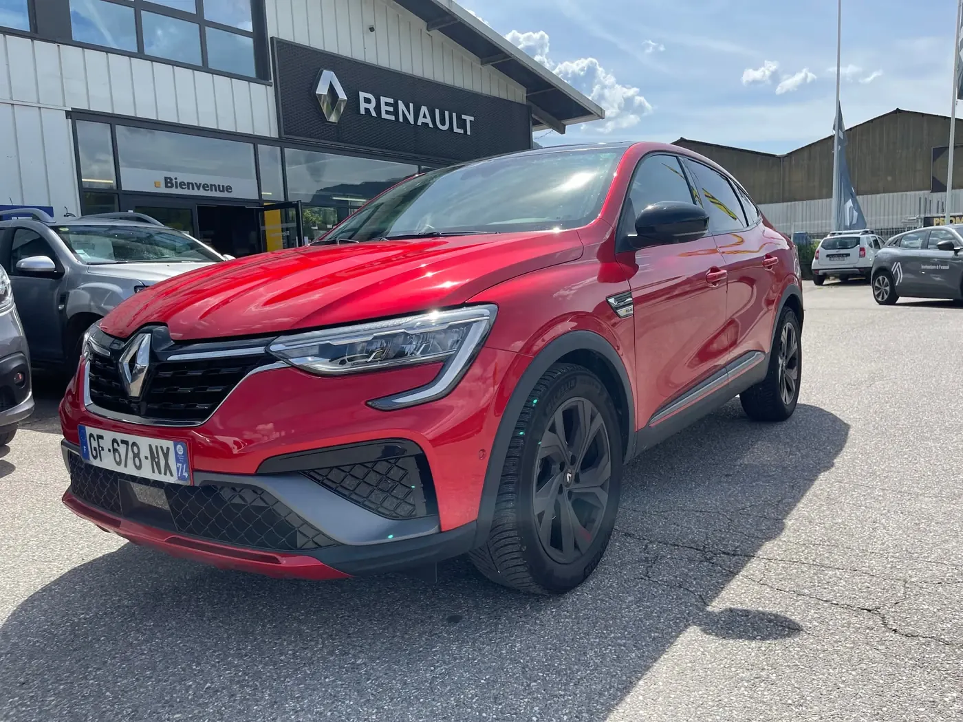 SUV rouge flamme, de trois quarts avant devant l'agence de Lescheraines