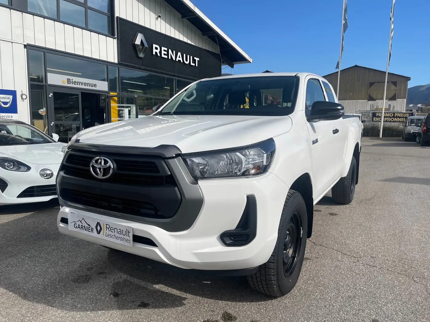 Pick-up blanc pur, de trois quarts avant devant l'agence de Lescheraines
