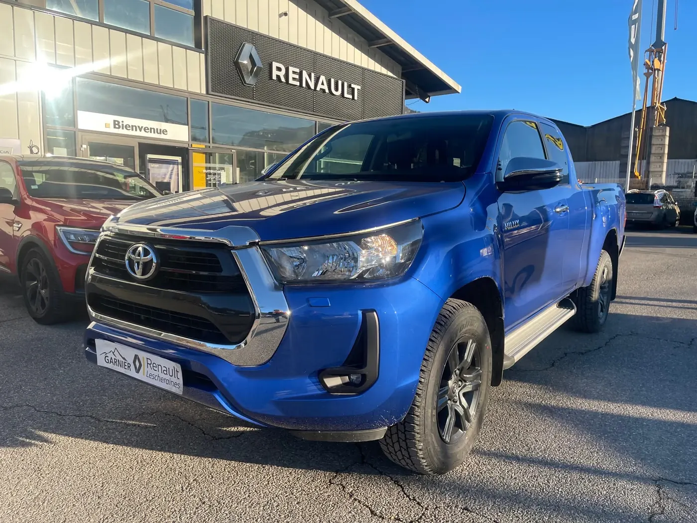 Un pick-up blanc sur le parvis de l'atelier
